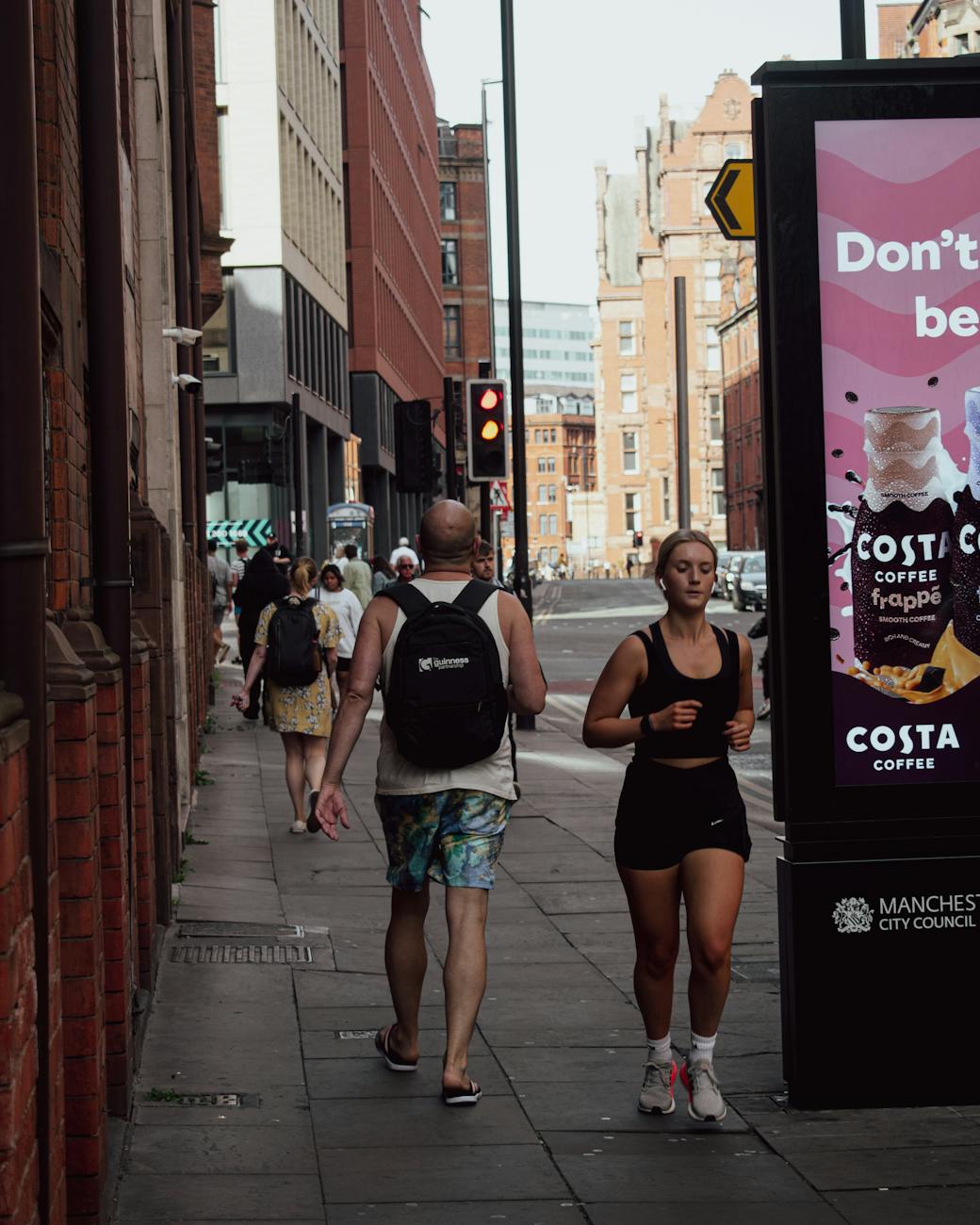 woman jogging on sidewalk in city