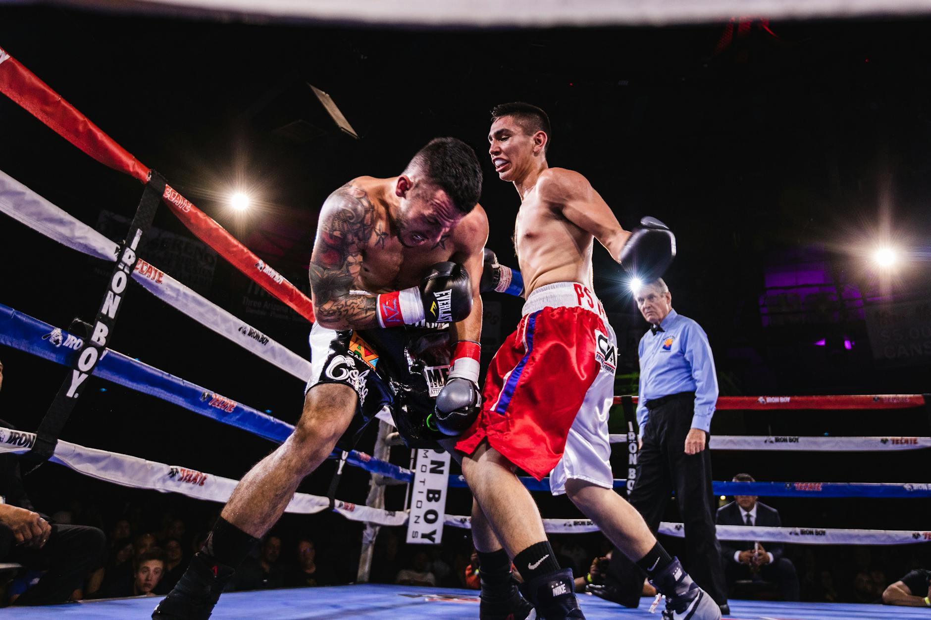 low angle photo of two men fighting in boxing ring