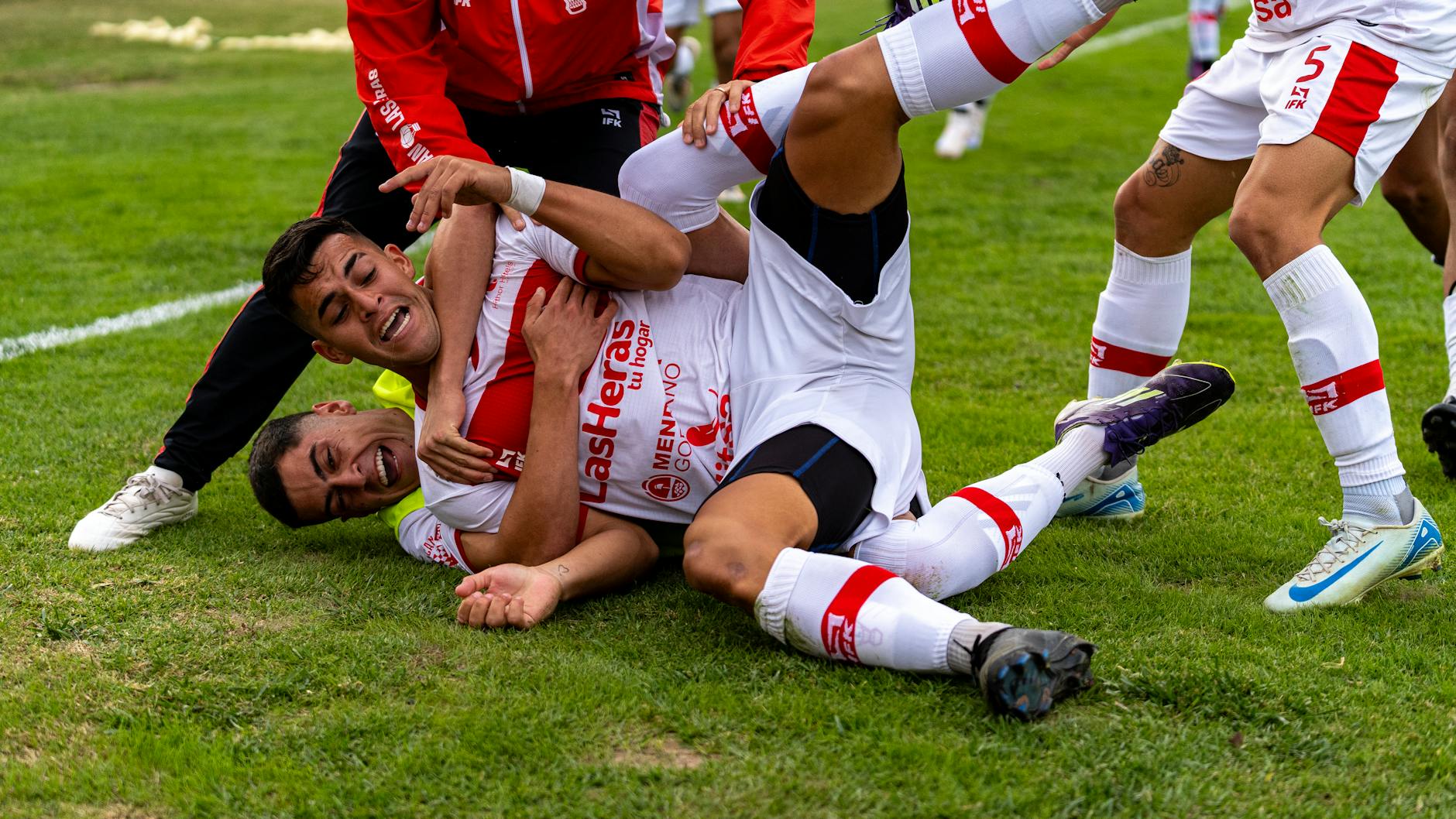 celebratory pile of soccer players on field